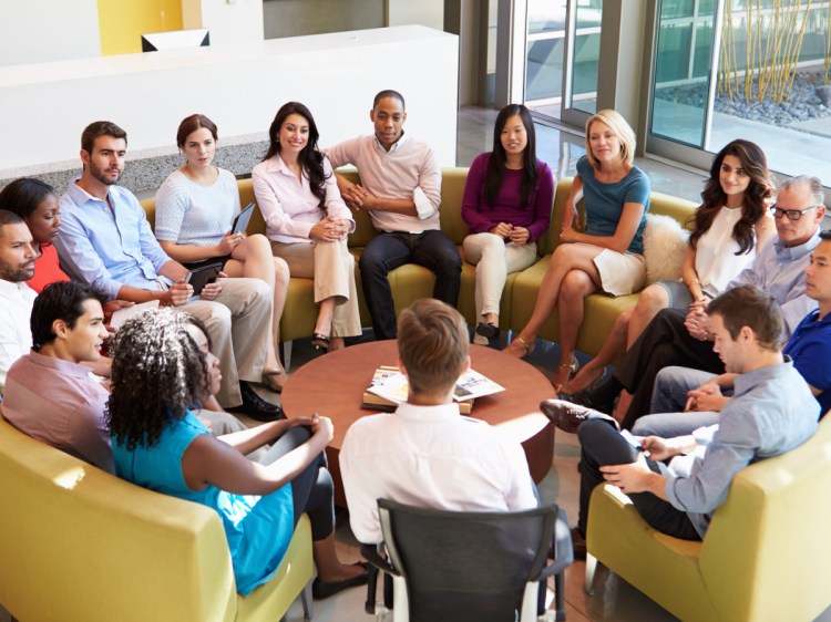 Multi-Cultural Office Staff Sitting Having Meeting Together